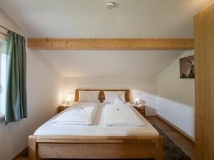 ein Schlafzimmer mit einem großen Bett mit weißer Bettwäsche in der Unterkunft Ferienwohnung Waldesruh in Kössen
