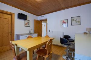 una sala da pranzo con tavolo e sedie in legno di Casa Cadore a Lozzo Cadore