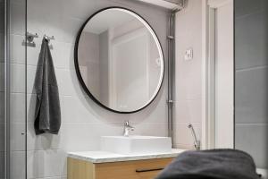 a bathroom with a sink and a mirror at HOMELY - Executive Suite 72m2 -Sauna in Helsinki