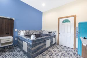 baño con bañera con pared azul en La Vyoma Villas, Westpark Hwy 6 en Houston