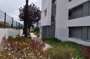 een wit gebouw met een tuin ervoor bij Apartamento Vanian Gardens Estepona in Estepona