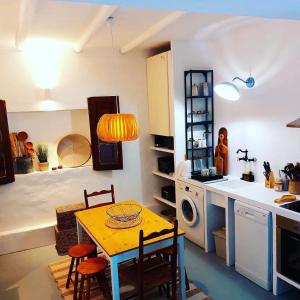eine Küche und ein Esszimmer mit einem Tisch und einer Mikrowelle in der Unterkunft Moradia com Piscina Casa Mourisca Alqueva in Mourão