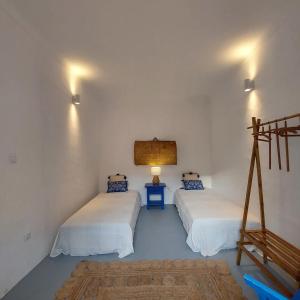 Zimmer mit 2 Betten und einer Lampe in der Unterkunft Moradia com Piscina Casa Mourisca Alqueva in Mourão