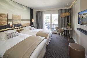a hotel room with two beds and a balcony at Thalazur Arcachon in Arcachon