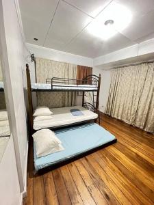 two bunk beds in a room with a wooden floor at House B Spacious 3BR3TB along Commonwealth Ave in Manila