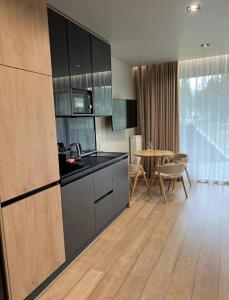 a kitchen with black counter tops and a table at Bukovel Village Apartments in Bukovel