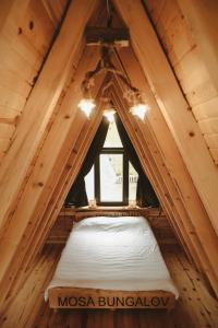 a small bed in a wooden room with a window at Mosa Bungalov in Ardeşen