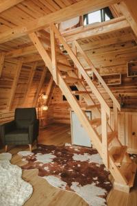 an attic room with a staircase and a chair at Mosa Bungalov in Ardeşen