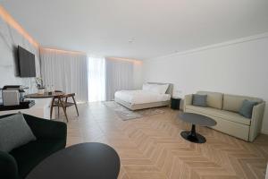 a living room with a couch and a bed at AKOYA HOTEL in Eilat