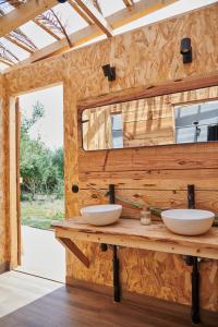 Baño con 2 lavabos en una pared de madera en Tranquilo Glamping, en Hozanejos