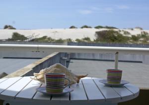 two cups on a table with a view of the beach at Barra Azul in Praia da Barra