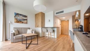 ミエルノにあるApartamenty Magnet Jantarisのソファとテーブルのあるリビングルームとキッチン