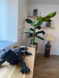 um brinquedo de dinossauro deitado numa mesa ao lado de uma planta em Gîte dans un hameau breton - 10 personnes 