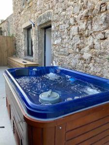 a blue tub filled with water in front of a building at Gîte dans un hameau breton - 10 personnes 