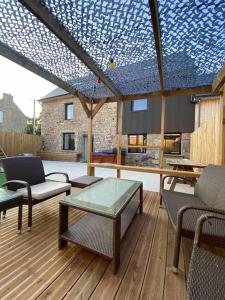 a patio with chairs and a table and a blue ceiling at Gîte dans un hameau breton - 10 personnes 