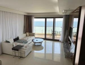 un soggiorno con divano e vista sull'oceano di Seopjikoji Oceanview Apartment a Seogwipo