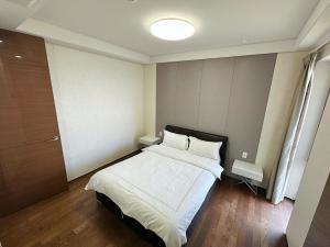 a bedroom with a bed with white sheets and pillows at Seopjikoji Oceanview Apartment in Seogwipo