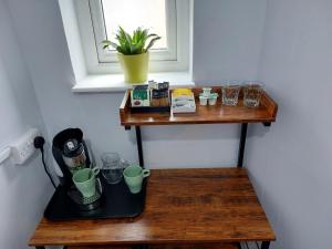 a wooden shelf with a coffee maker and glasses on it at Southwell Stays in Southwell