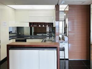 a kitchen with white cabinets and a counter top at Seopjikoji Oceanview Apartment in Seogwipo