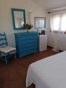 una camera da letto con cassettiera blu e sedia blu di Dalla Manu 1/2 a Porto Istana