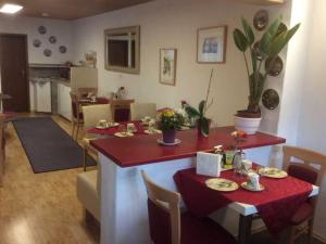 un salon avec une table et un tissu de table rouge dans l'établissement Gästehaus am Lindenweg, à Meersburg