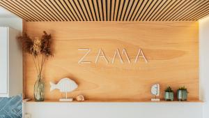 una parete di legno con un cartello zamana di ZAMA Apartment ad Acantilado de los Gigantes