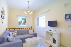 a living room with a couch and a tv at Villa Kalithea in Nisaki