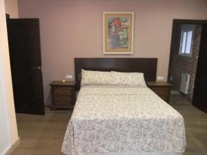 1 dormitorio con 1 cama con colcha blanca en Chalet La Serreta, en Alicante