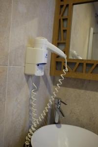 Hay un secador de pelo en la pared de un baño. en Ceneviz Hotel en Adrasan