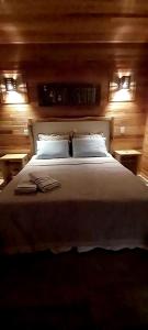 1 dormitorio con 1 cama blanca grande y 2 almohadas en Pousada Sentiero, en Urubici