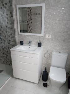y baño con lavabo, aseo y espejo. en oasis en Tenerife 3 en El Escobonal
