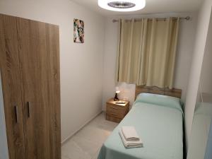 niewielka sypialnia z łóżkiem i biurkiem z laptopem w obiekcie oasis en Tenerife 3 w mieście El Escobonal