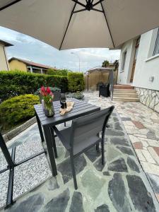 una mesa de picnic con una sombrilla en el patio en La Mirage en Desenzano del Garda