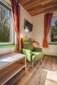 a living room with a green chair and a table at Gintarautojai in Palanga