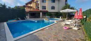 una piscina di fronte a una casa con ombrellone di Oasis Beach Home Four a Lozenets