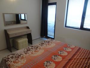 a bedroom with a bed and a dresser and a mirror at Oasis Beach Home Four in Lozenets