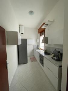 a kitchen with a sink and a refrigerator at A due passi dal Mare in Castiglione della Pescaia
