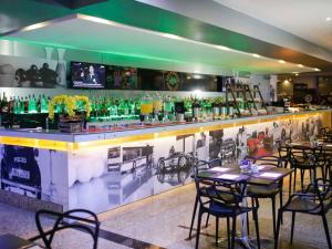 a bar with tables and chairs in a restaurant at Flat Mercure 1km do Planalto Central h07 in Brasilia