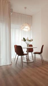 uma sala de jantar com mesa e cadeiras em So Fine Petruzzelli flat em Bari
