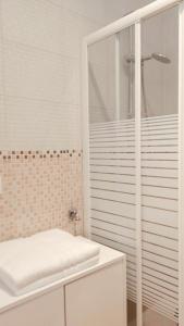 uma casa de banho branca com um chuveiro e um lavatório. em So Fine Petruzzelli flat em Bari