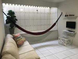 ein Wohnzimmer mit einem Sofa und einer Hängematte in der Unterkunft Excelente casa 300m2 em Bairro Nobre perto de tudo in Natal