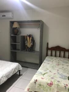 um quarto com uma cama e uma prateleira com uma cama em Excelente casa 300m2 em Bairro Nobre perto de tudo em Natal