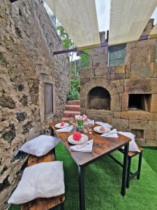 uma mesa e cadeiras com um forno de pedra em La Casa del Sole em Pantelleria