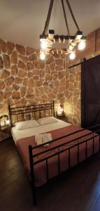 um quarto com uma cama numa parede de pedra em Casa Bella a Skala 3 em Skála Kefalonias