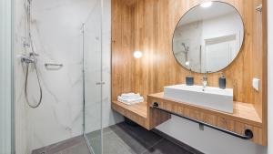 ミエルノにあるApartamenty Magnet Jantarisの洗面台と鏡のあるバスルーム
