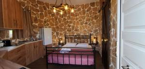 um quarto com uma cama e uma parede de pedra em Casa Bella a Skala 3 em Skála Kefalonias
