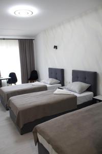Cette chambre comprend 2 lits et une table. dans l'établissement Forsage Hotel, à Oujhorod