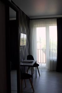 ein Esszimmer mit einem Tisch und einem Fenster in der Unterkunft Forsage Hotel in Uschhorod