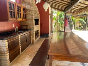une cuisine avec un comptoir en bois et une table en bois dans l'établissement Casa MYM BOUGANVILLE 1 e 2, à Jericoacoara