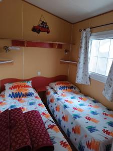 a bedroom with two beds and a window at Mobil home 6 personnes climatisation Sainte Croix du Verdon - Gorges du Verdon in Sainte-Croix-de-Verdon